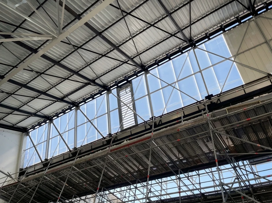 Chantier extérieur de toiture avec ouvrier appliquant un revêtement d'étanchéité au chalumeau sur membrane bitumineuse