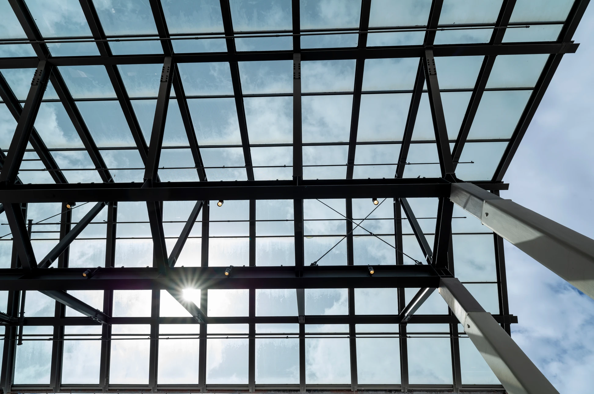 Intérieur d'un bâtiment en rénovation avec vue en contre-plongée sur une toiture transparente