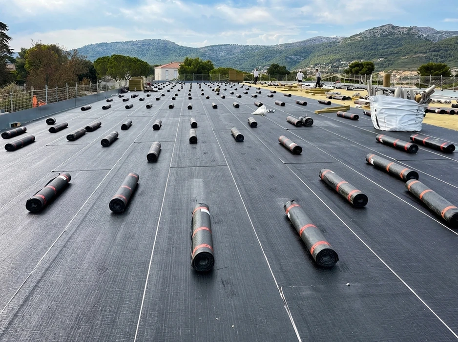 Terrasse en béton sur toit d'immeuble urbain avec garde-corps en béton, située entre tours résidentielles modernes