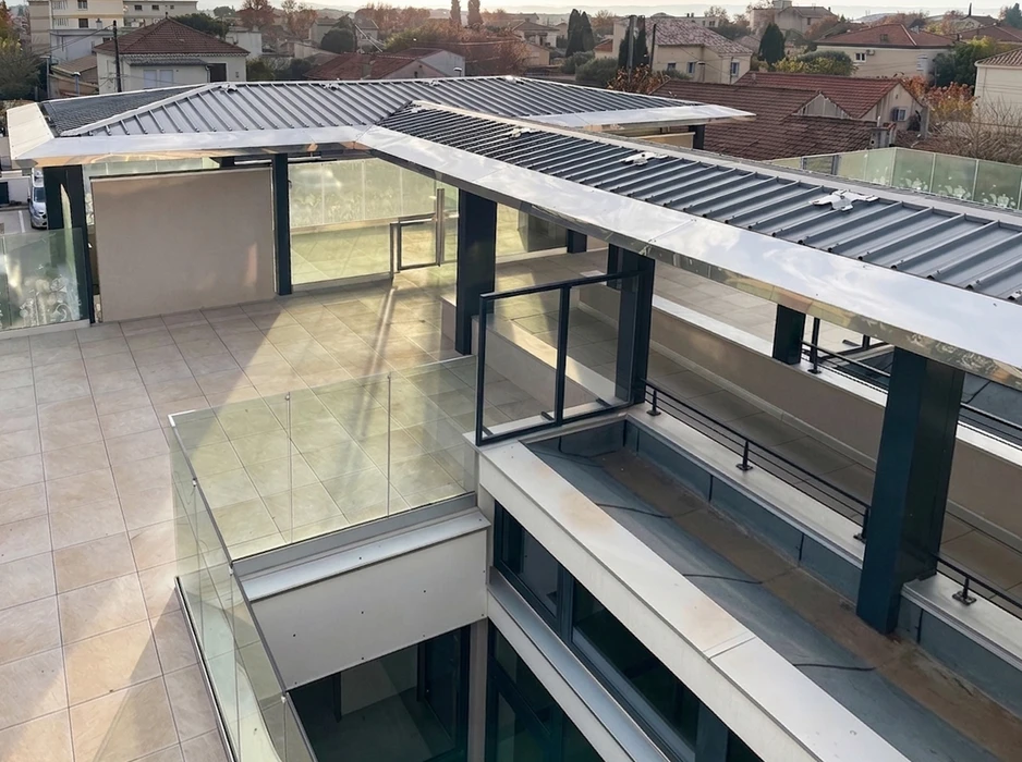 Toiture industrielle en tôle ondulée galvanisée sous ciel nuageux