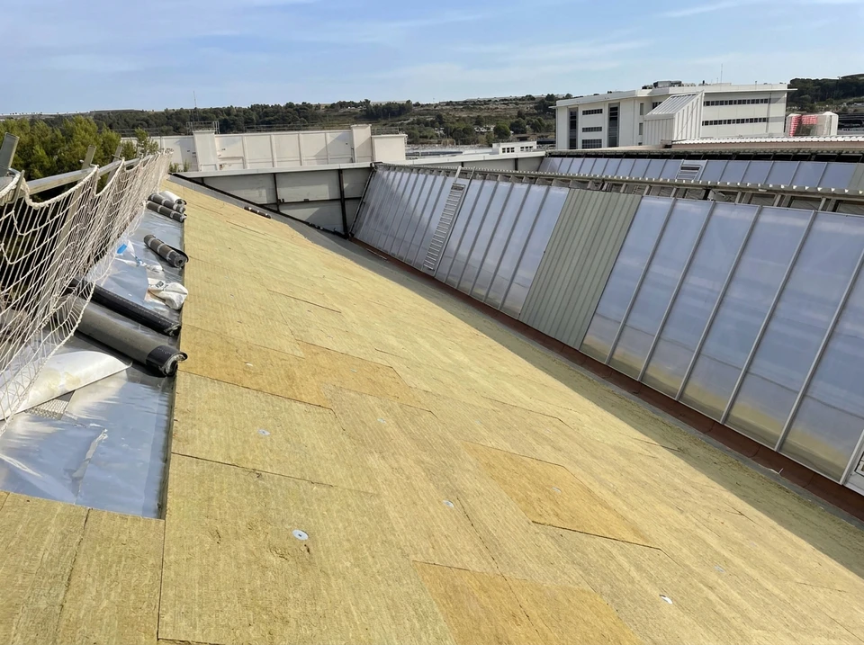 Intérieur d'un bâtiment en rénovation avec vue en contre-plongée sur une toiture transparente